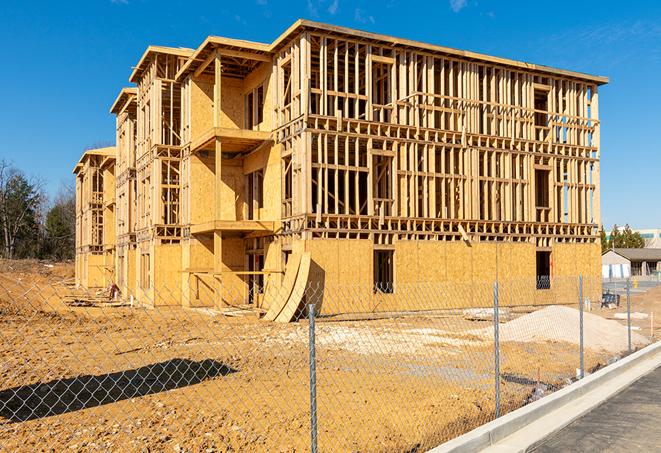 workers protected by temporary barrier fence during building maintenance in Honey Creek